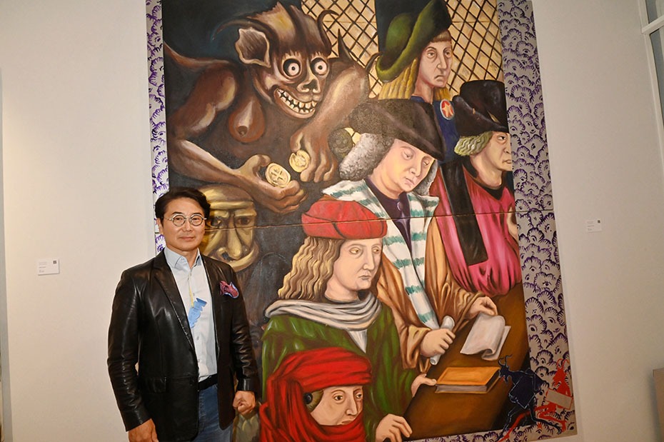 Le galleriste Dong Jo Chang pose avec un tableau de Manuel Ocampo representant  un Dracula Philippin en embuscade